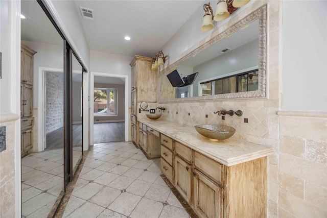 bathroom with vanity and tasteful backsplash