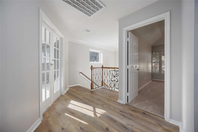 corridor with hardwood / wood-style flooring and french doors