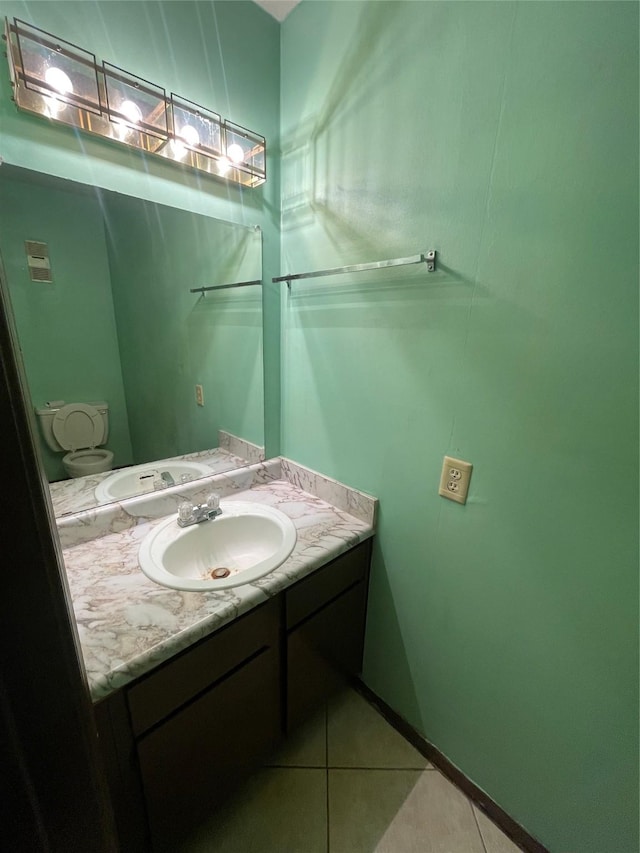 bathroom featuring tile patterned flooring, vanity, and toilet