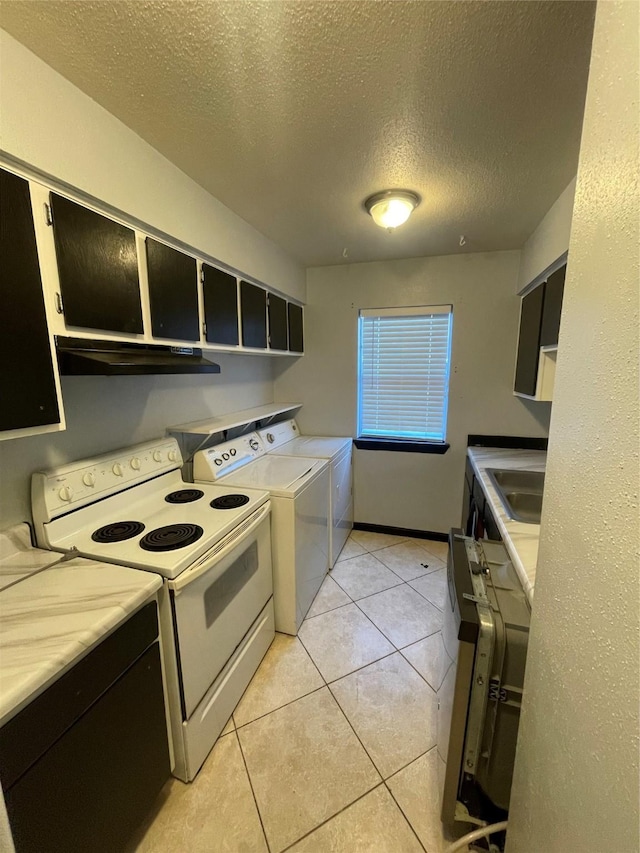 kitchen with a textured ceiling, sink, washer and dryer, light tile patterned floors, and electric stove