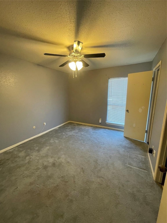 carpeted empty room with ceiling fan and a textured ceiling