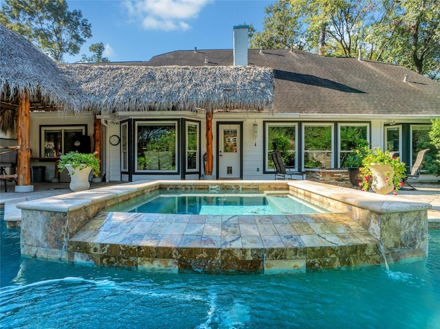 view of pool featuring an in ground hot tub and pool water feature