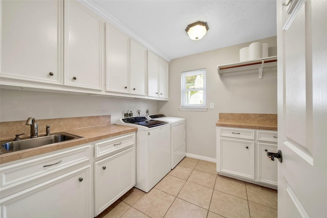 laundry area featuring washer and dryer, light tile patterned floors, cabinets, and sink