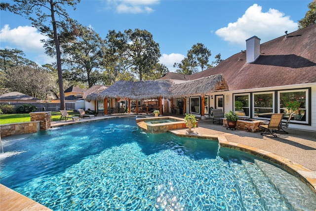 view of swimming pool featuring an in ground hot tub, pool water feature, and a patio