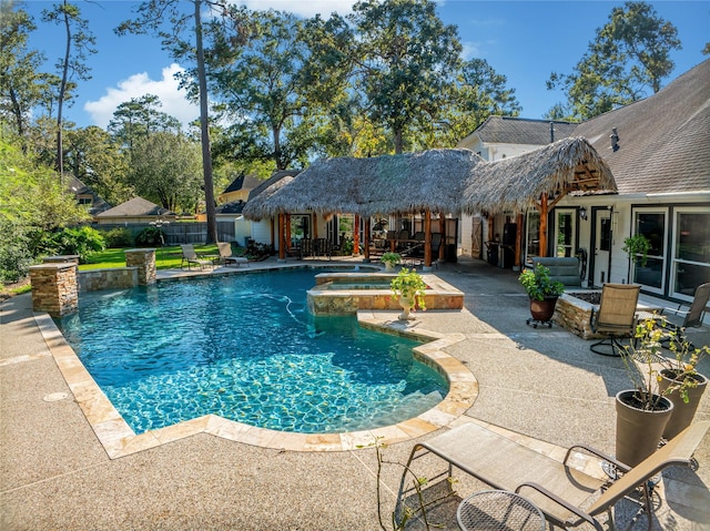 view of swimming pool with pool water feature, an in ground hot tub, and a patio