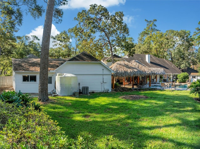 rear view of house with a lawn, central AC, and a patio