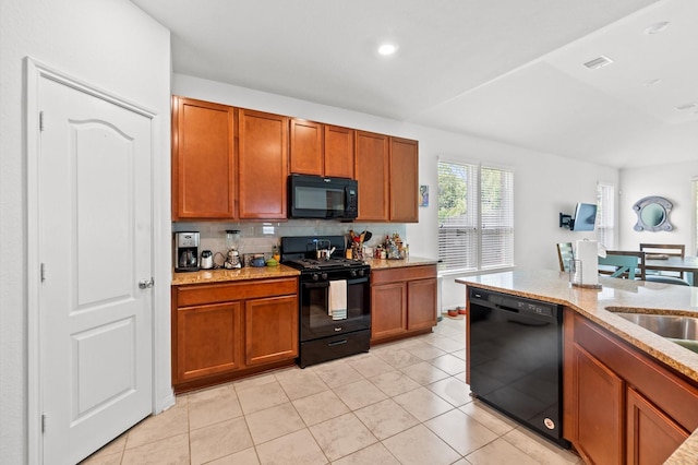 kitchen with black appliances, sink, tasteful backsplash, light tile patterned flooring, and light stone counters