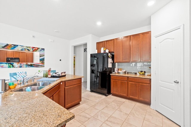 kitchen featuring black appliances, sink, decorative backsplash, light tile patterned floors, and light stone counters