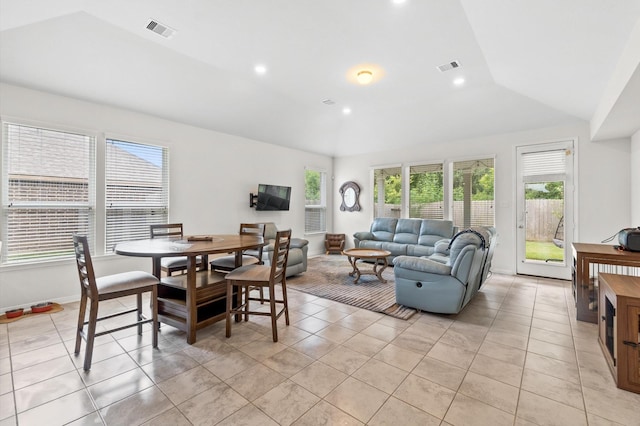 tiled dining space featuring a wealth of natural light and vaulted ceiling