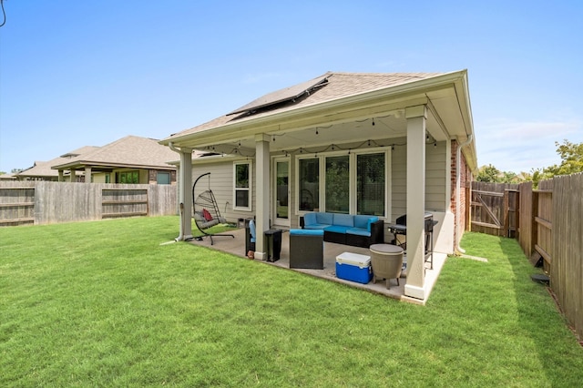 back of property with outdoor lounge area, solar panels, a patio area, and a yard