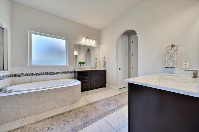 bathroom with vanity and a relaxing tiled tub