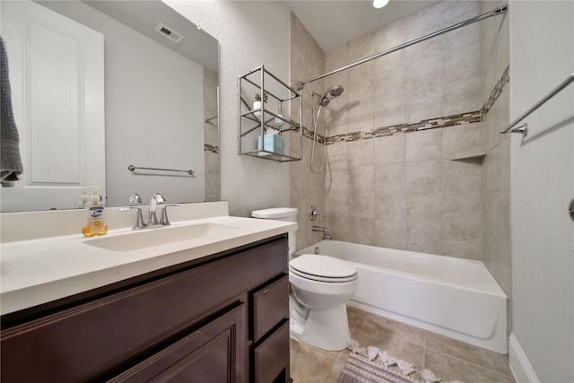 full bathroom featuring tile patterned flooring, toilet, vanity, and tiled shower / bath