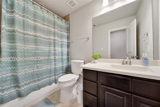 full bathroom featuring tile patterned floors, vanity, shower / bath combination with curtain, and toilet