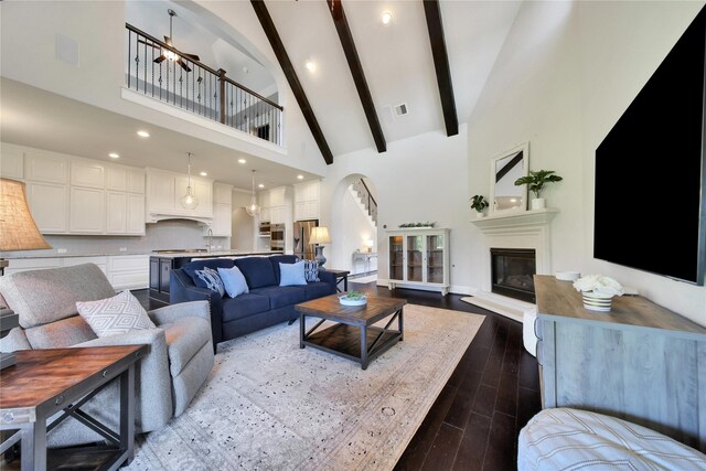 living room with beamed ceiling, a notable chandelier, and high vaulted ceiling