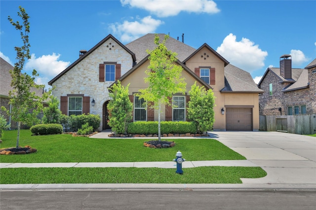 view of front of property with a garage and a front lawn