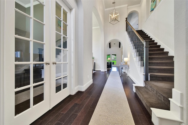 foyer entrance featuring crown molding, french doors, and a chandelier