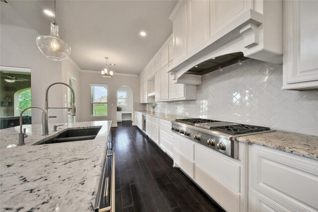 kitchen featuring white cabinetry, sink, stainless steel gas cooktop, pendant lighting, and custom exhaust hood