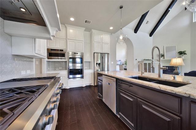 kitchen with white cabinets, sink, vaulted ceiling with beams, appliances with stainless steel finishes, and extractor fan