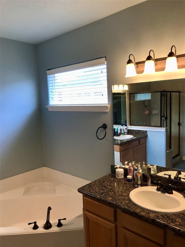 bathroom featuring vanity and independent shower and bath