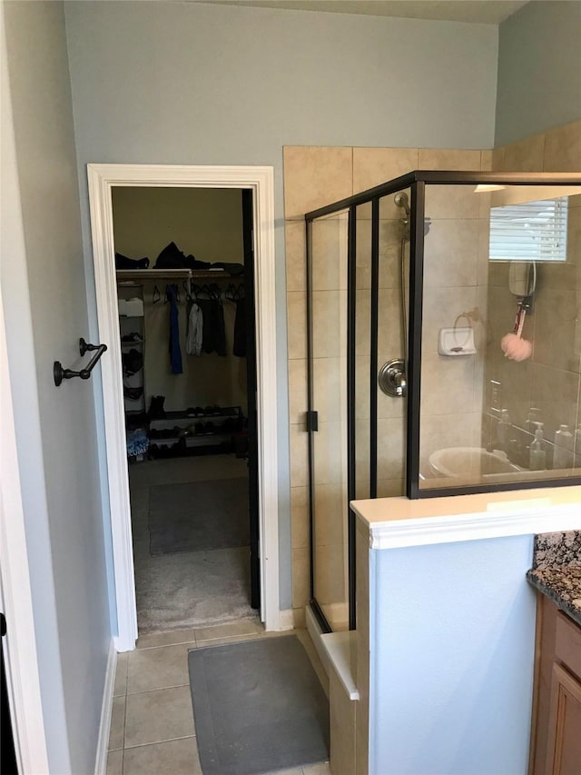 bathroom with tile patterned floors, vanity, and a shower with shower door