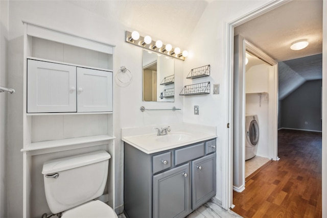 bathroom featuring hardwood / wood-style floors, vanity, washer / clothes dryer, and toilet