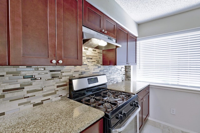 kitchen with light stone countertops, gas stove, tasteful backsplash, and a healthy amount of sunlight