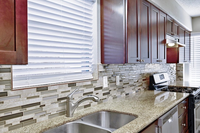 kitchen featuring light stone countertops, sink, dishwasher, range with gas cooktop, and decorative backsplash