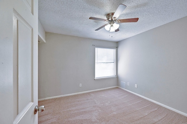 carpeted empty room featuring ceiling fan and a textured ceiling