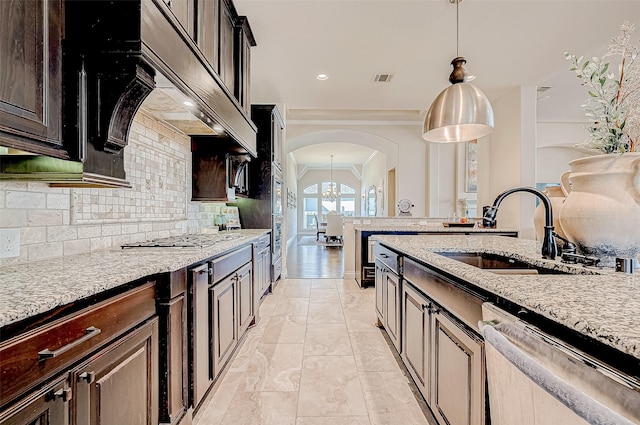 kitchen with dark brown cabinetry, sink, stainless steel appliances, and ornamental molding