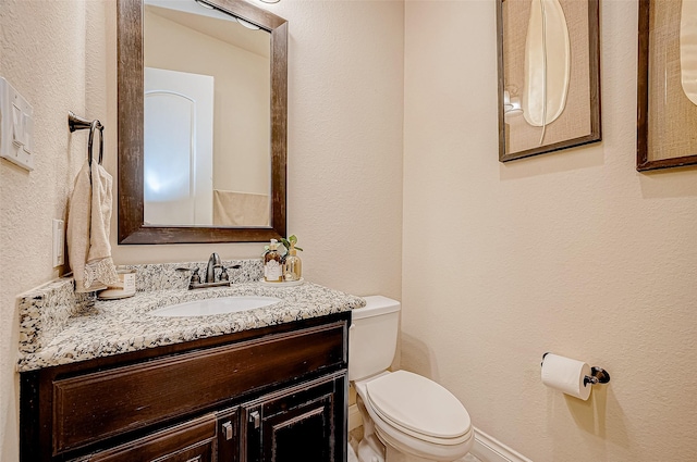 bathroom featuring vanity, toilet, and lofted ceiling