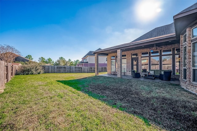 view of yard with outdoor lounge area, ceiling fan, and a patio