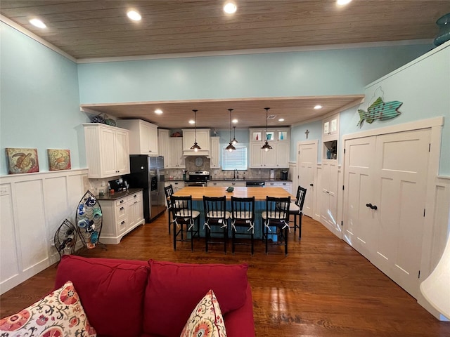 dining area with dark hardwood / wood-style floors, wood ceiling, and sink