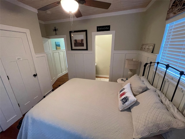 bedroom featuring wainscoting, crown molding, and ceiling fan