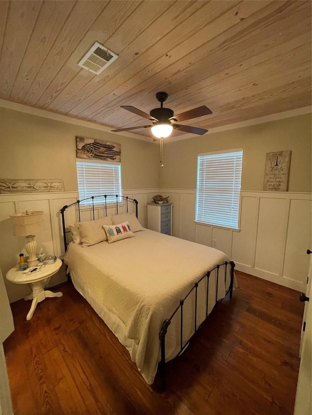 bedroom featuring ceiling fan, dark hardwood / wood-style flooring, wooden ceiling, and crown molding