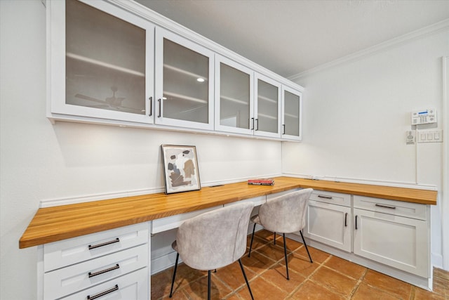 office area with built in desk and ornamental molding