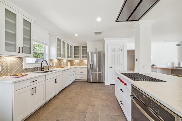 kitchen featuring sink, decorative backsplash, ornamental molding, appliances with stainless steel finishes, and white cabinetry