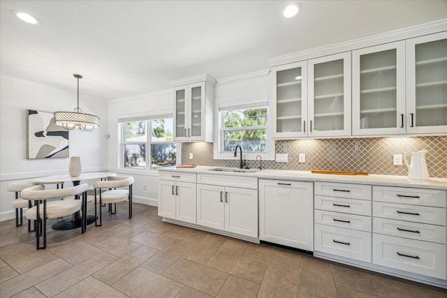 kitchen featuring white cabinetry, sink, hanging light fixtures, crown molding, and white dishwasher