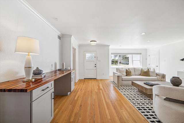 living room featuring light hardwood / wood-style flooring and crown molding