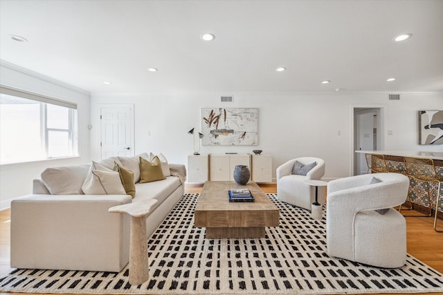 living room featuring hardwood / wood-style flooring and ornamental molding