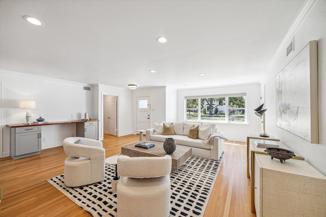 living room with light wood-type flooring and crown molding