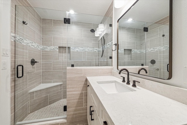 bathroom featuring vanity and a shower with door