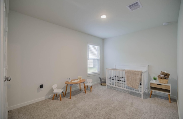 bedroom featuring light carpet and a crib