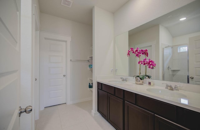 bathroom with tile patterned floors, vanity, and walk in shower