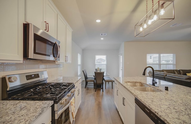 kitchen with light stone countertops, white cabinetry, sink, and stainless steel appliances