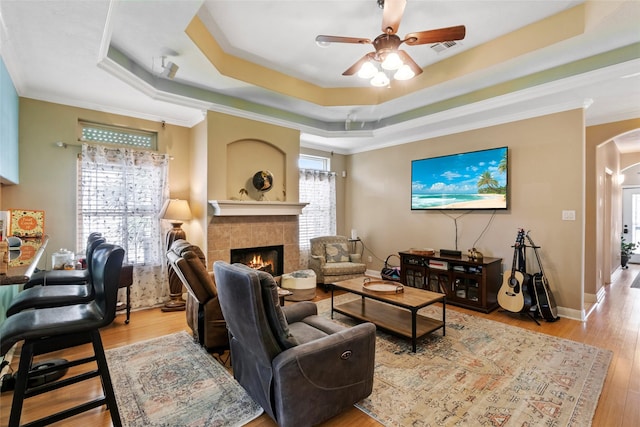 living room featuring a healthy amount of sunlight, crown molding, and a tray ceiling