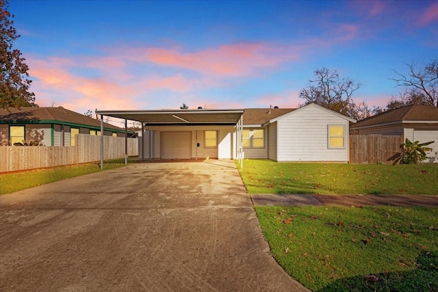 ranch-style house featuring a carport and a lawn