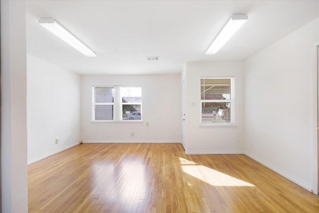 spare room with plenty of natural light and light hardwood / wood-style floors