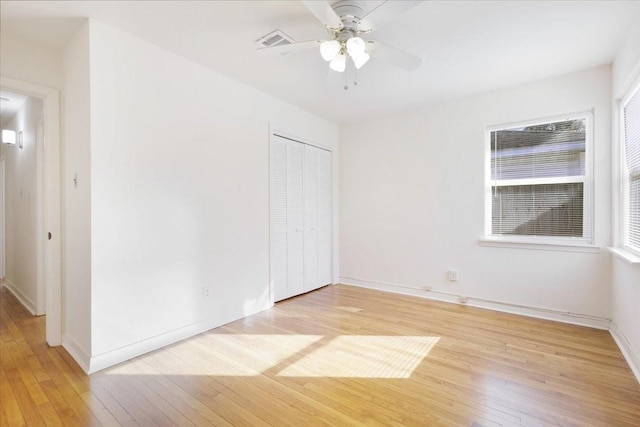 unfurnished bedroom with ceiling fan, light wood-type flooring, and a closet