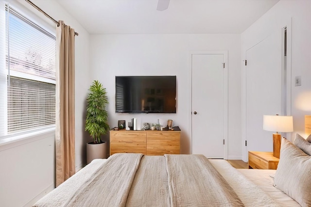 bedroom with wood-type flooring, multiple windows, and ceiling fan