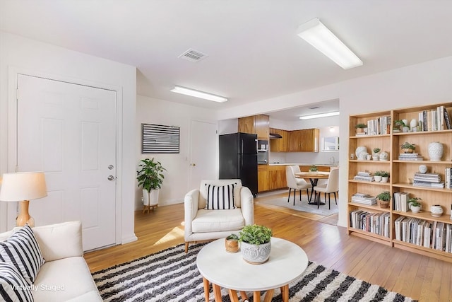 living room with sink and light hardwood / wood-style floors